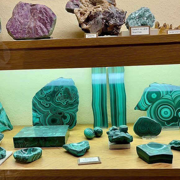 in einer Vitrinen sind Edelsteine verschiedener Farben zu sehen